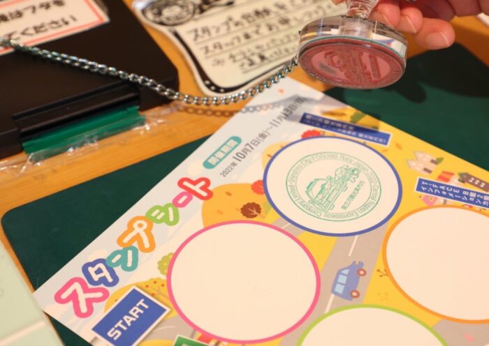A traveler stamping their sheet at a Japanese stamp rally — each unique design turns the journey into a memorable adventure."